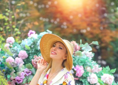 Sexy and dreamy blond girl in a summer elegant dress and hat in nature. Elegance and style. Beauty concept.