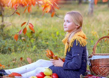 Sonbahar parkında oturan dalgın beyaz kız. Çocuk psikolojisi ve eğitim kavramı