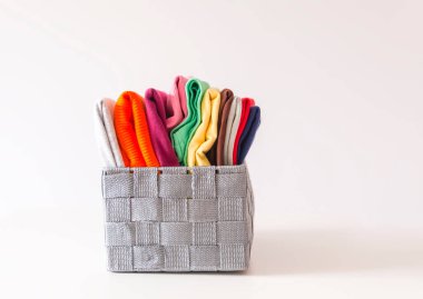 Kutuda katlanmış renkli kıyafetler var. Ev düzenleme. Ev içi dikey depolama.