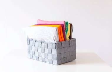 Kutuda katlanmış renkli kıyafetler var. Ev düzenleme. Ev içi dikey depolama.