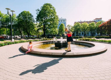 Parkta scooter süren genç kız kardeşler.