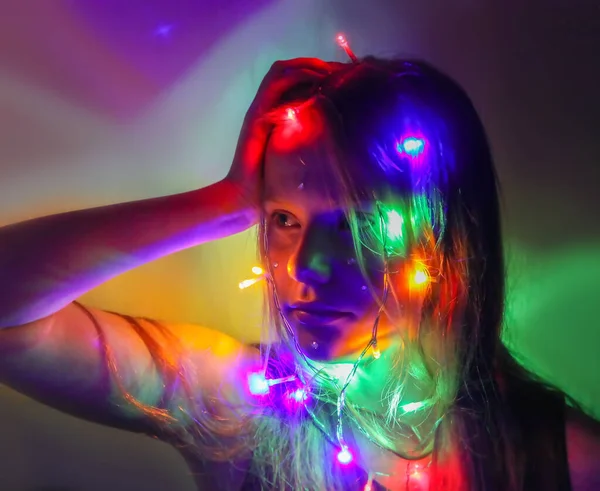 Bir kız elinde güzel parlak ışıklar tutar. Evde sihirli ışıklarla oynayan çocuk.