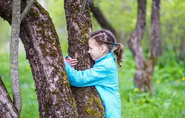 Счастливая Маленькая Девочка Обнимает Дерево Весеннем Саду — стоковое фото