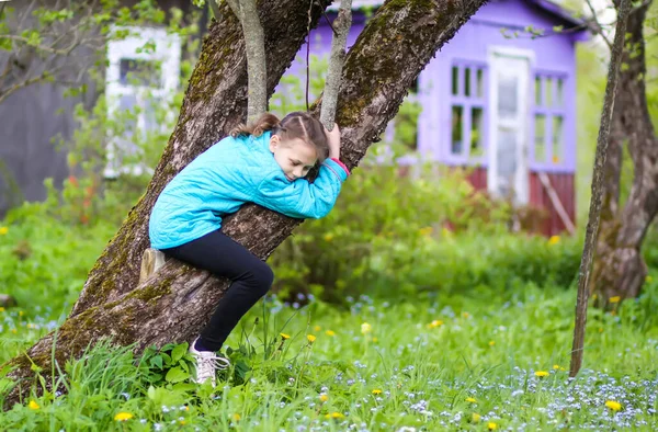 幸せな女の子は春の庭で木を抱きしめる — ストック写真
