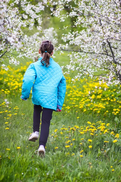幸せな女の子は春の庭を歩く — ストック写真