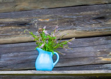 Bitki çayı için taze organik çiçek açan nane bitkileri. Şifalı bitkiler. Mavi seramik sürahi içinde bir buket tıbbi çiçek.
