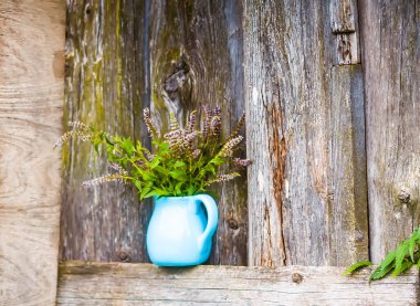 Bitki çayı için taze organik çiçek açan nane bitkileri. Şifalı bitkiler. Mavi seramik sürahi içinde bir buket tıbbi çiçek.