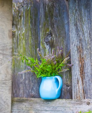 Bitki çayı için taze organik çiçek açan nane bitkileri. Şifalı bitkiler. Mavi seramik sürahi içinde bir buket tıbbi çiçek.