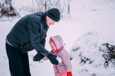 Babası ve küçük tatlı kızı kış günü dışarıda eğleniyorlar..