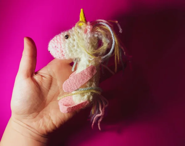 A knitted unicorn. A soft handmade toy for a child.