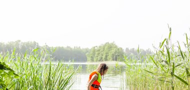 Gölde yüzerken can yeleği giyen liseli bir kız..