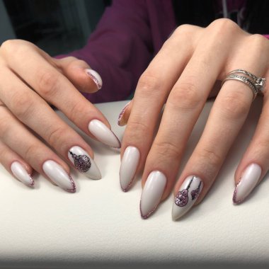 The hand of a young woman with a white manicure and design for the New Year and Christmas.Manicure beauty salon concept. Empty place for text or logo.
