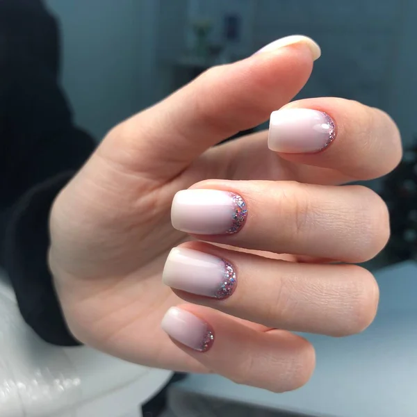 Hands of a woman with pink manicure on nails.Manicure beauty salon concept. Empty place for text or logo.