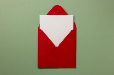 Kırmızı zarfın içinde yeşil arka planda beyaz notlar var. Tebrikler mektup. Tatiller ve aşk kavramları. Boşluğu kopyala.