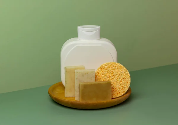 Creative Composition White Bottle Soap Sponge Wooden Plate Green Background — Stock Fotó