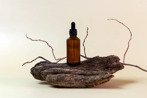 Aromatik yağlı ya da serumlu cam şişeler, kopyalanmış ağaç kabuğu. Doğal organik kozmetik spa konsepti. Minimum konsept. Ürün için maket. Çevre dostu. Kahverengi arkaplan.