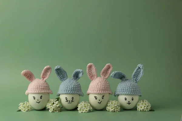 Paskalya tavşanı ve bahar çiçeği şeklinde örülmüş şapkalı yumurtalarla moda bir kompozisyon. Metin için bir paskalya kartı ve yerin bir kopyası..