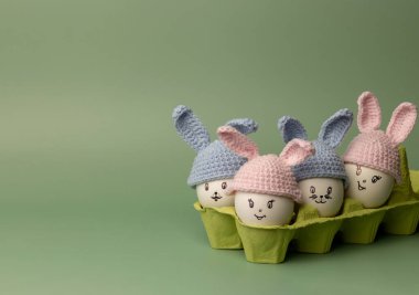 Yeşil arka planda yumurtadan yapılmış Paskalya tavşanlarıyla moda bir kompozisyon. Metin için bir paskalya kartı ve yerin bir kopyası..