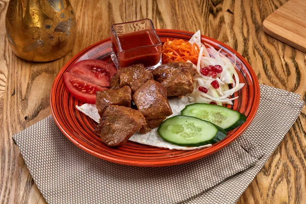 Geleneksel Rus şiş kebap ızgara şiş ve ahşap bir masada sebzeler.