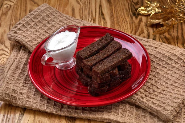 Kırmızı tabakta garlick ekşi krema soslu kızarmış ekmek. Biralar ahşap masada..