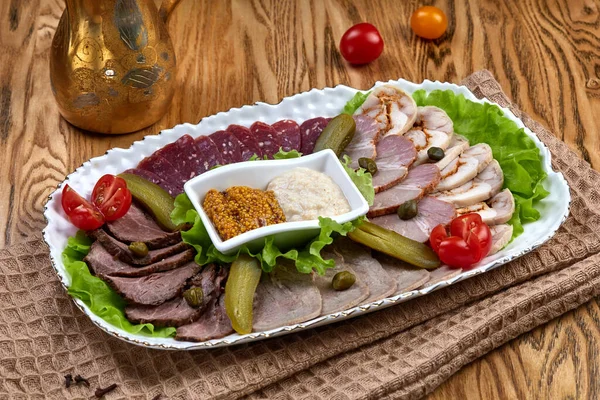 Bir tabak çeşit et ve soslu sosis.