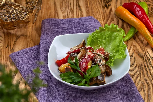 Restorandaki ahşap masada ızgara sebze salatası. 