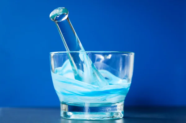 Стеклянный раствор и пестик со смесью синих и белых соединений — стоковое фото