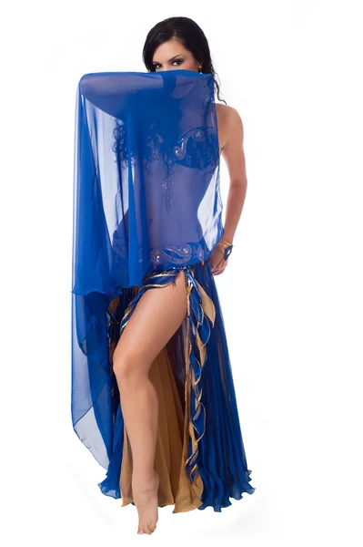 Exotic belly dancer wearing a blue costume and holding a blue veil in front of her face. — Stock Photo, Image