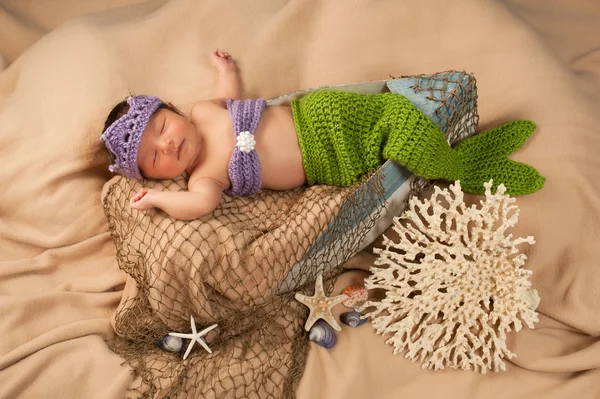 Newborn baby girl wearing a crocheted green and lavender colored mermaid costume. — Stock Photo, Image