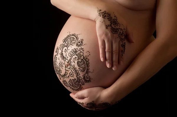 Паста татуировки Хенны на руках женщины и беременном животе . — стоковое фото