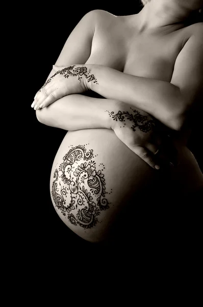 Henna tetování pasta na ruce ženy a těhotné břicho. — Stock fotografie