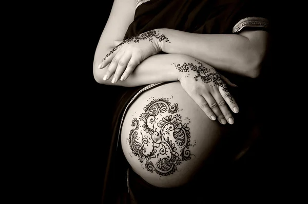 Henna tatuering klistra på en kvinnas händer och gravid mage. — Stockfoto