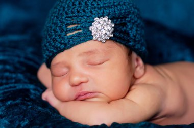bir deniz mavisi battaniye uyku ve deniz mavisi tığ işi sineklik tarzı şapka elmas taklidi süsleme ile yeni doğan kız.