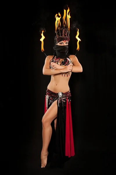 Egzotik dansöz kırmızı ve siyah giyen hijab ile kılık ve yangın headdress ve yangın wands holding. — Stok fotoğraf