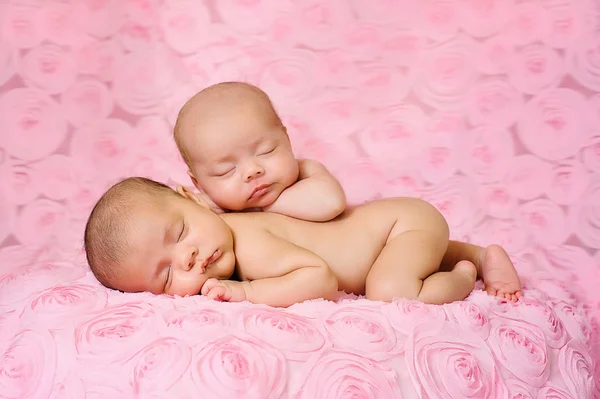 Neugeborene Mädchen schlafen auf rosa, dreidimensionalem Rosenstoff. — Stockfoto