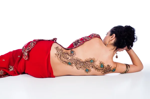 Mujer en un sari rojo con un diseño de henna de plumas de pavo real en su espalda . —  Fotos de Stock