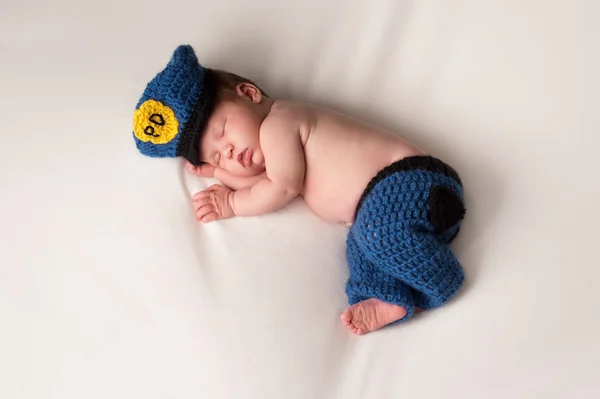 Pasgeboren baby het dragen van een kostuum politieagent — Stockfoto