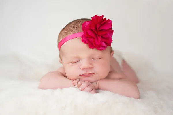 Νεογέννητο μωρό κορίτσι με ζεστό ροζ flower κεφαλόδεσμος Εικόνα Αρχείου