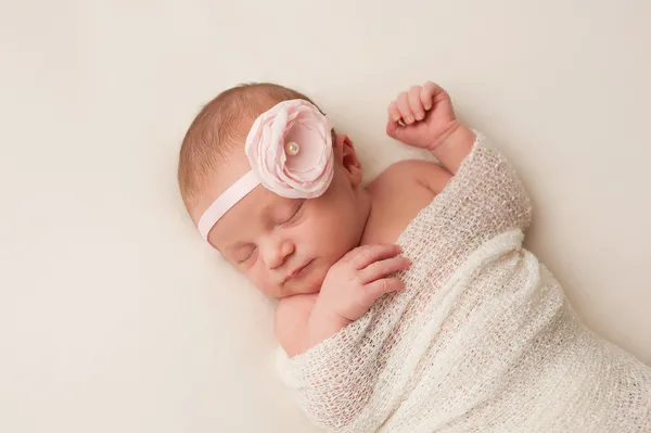 Bebé recién nacido con diadema de flor rosa claro — Foto de Stock