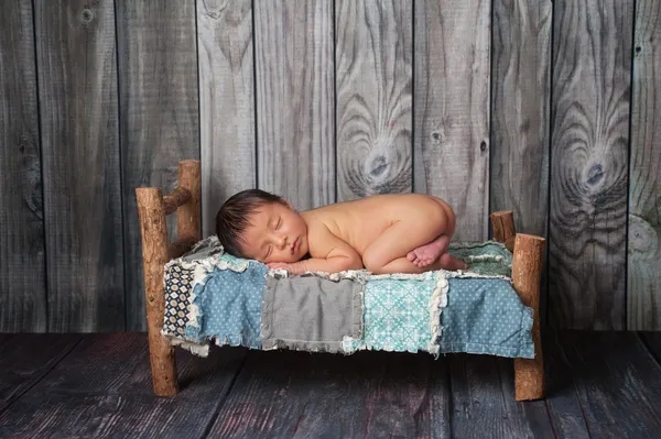 Menino recém-nascido dormindo em uma pequena cama — Fotografia de Stock