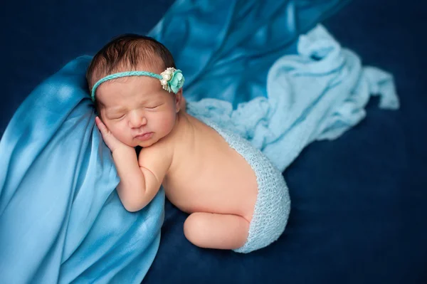 Novorozená holčička s modrou čelenkou — Stock fotografie