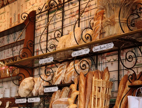 Panes frescos y crujientes y baguettes en exhibición en una panadería local, donde se pueden oler cocinando en el horno durante todo el día. . —  Fotos de Stock