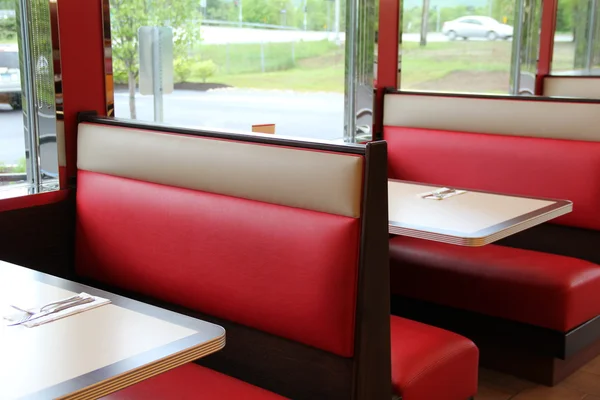 Cabinas coloridas y mesas de madera en el restaurante local Imágenes de stock libres de derechos