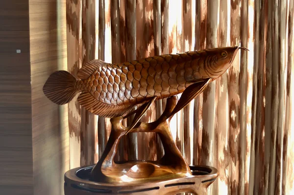 Jambi şehrinden oyma bir sanatçı tarafından oyulmuş arowana balığı şeklinde ahşap oyma sanatı.