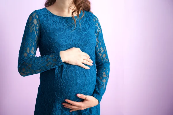 Lacivert elbiseli hamile bir kadın mide