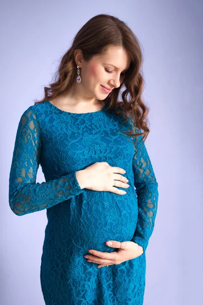 怀孕的女人抱着她的肚子 — 图库照片