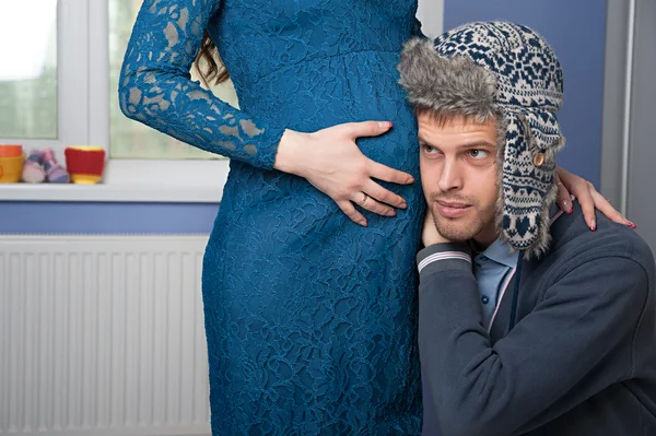 Mannen försöker lyssna hustruns mage — Stockfoto