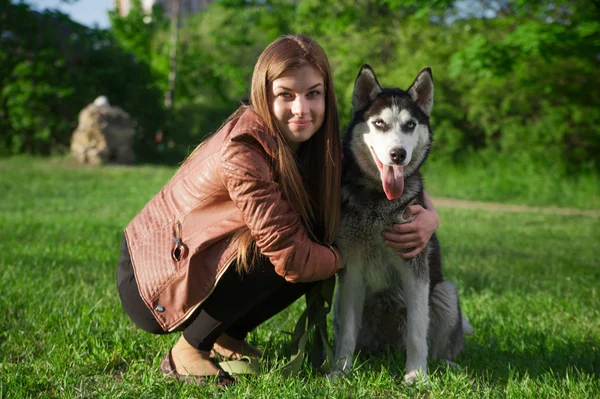 La chica se está divirtiendo con su perro en el parque — Foto de Stock