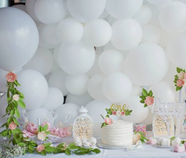 Beyaz kremalı ilk doğum günü pastası, kağıt çiçekli altın pasta süsü. Küçük kız için beyaz doğum günü partisi