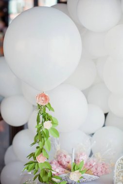 Beyaz balonlar kağıt çiçekli çelenkler, tatlılar ve dekorasyonlar doğum günü partisinde tatlı bir masada.